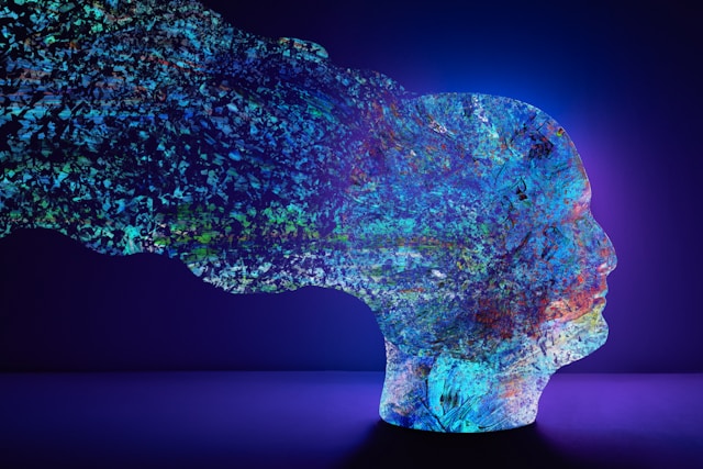 Digital image of a human head fragmenting into tiny particles to show the complexity of brain patters in Neuroscience.