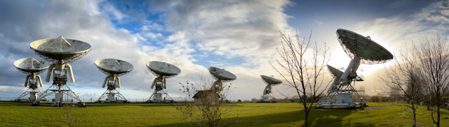 Image of a group of 8 ground satellites pointing up to the sky to communicate