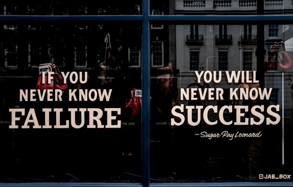 Image of a boxing gym window with quote by Sugar Ray Leonard saying "If you never know failure, you will never know success".